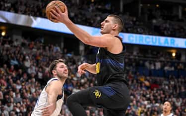 DENVER, CO - DECEMBER 18: Nikola Jokic (15) of the Denver Nuggets gets athletic as he blows by Luka Doncic (77) of the Dallas Mavericks during the first quarter at Ball Arena in Denver on Monday, December 18, 2023. (Photo by AAron Ontiveroz/The Denver Post)