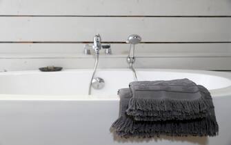 Modern ceramic bathtub with towels.