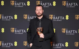 epa11164743 Mstyslav Chernov poses with the Documentary Award for '20 Days in Mariupol' in the press room during the BAFTA Film Awards at the Royal Festival Hall in London, Britain, 18 February 2024. The ceremony is hosted by the British Academy of Film and Television Arts (BAFTA).  EPA/ANDY RAIN