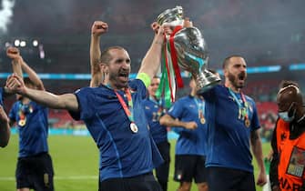 Italy's Giorgio Chiellini and Leonardo Bonucci carry the trophy and celebrate with team-mates after winning the penalty shoot-out after the UEFA Euro 2020 Final at Wembley Stadium, London. Picture date: Sunday July 11, 2021.  PA Photo. See PA story SOCCER England. Photo credit should read: Nick Potts/PA Wire.

RESTRICTIONS: Use subject to restrictions. Editorial use only, no commercial use without prior consent from rights holder.