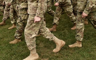 US soldiers legs in green camouflage military uniform. US troops