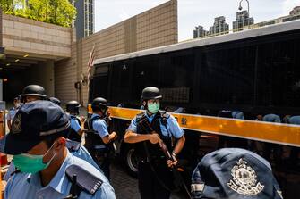 HONG KONG, CHINA - JULY 06: Police stand guard as defendant Tong Ying-kit, 23, arrives the court - Tong accused of deliberately driving his motorcycle into a group of police officers, is the first person charged for incitement to secession and terrorist activities under the national security law, on July 6, 2020 in Hong Kong, China. (Photo by Billy H.C. Kwok/Getty Images)