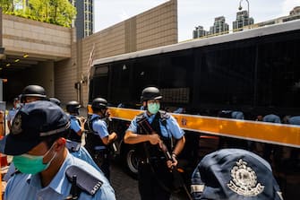 HONG KONG, CHINA - JULY 06: Police stand guard as defendant Tong Ying-kit, 23, arrives the court - Tong accused of deliberately driving his motorcycle into a group of police officers, is the first person charged for incitement to secession and terrorist activities under the national security law, on July 6, 2020 in Hong Kong, China. (Photo by Billy H.C. Kwok/Getty Images)