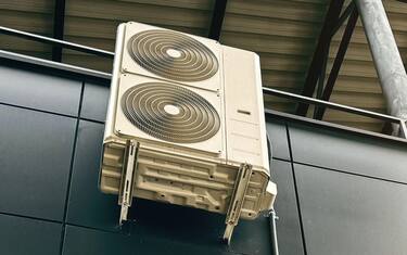 Industrial air conditioning units mounted on a modern glass and steel building