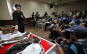 epa10925049 Lecturer of the Geology Department of Chulalongkorn University, Assistant Professor Kantapon Suraprasit explains the paleontological discovery of a fossil of a new ancient alligator species  'Alligator Munensis', during a press conference at the Mineral Resources Department in Bangkok, Thailand, 18 October 2023. The new species Alligator Munensis' fossil was discovered in April 2005 in Nakhon Ratchasima province of Thailand and is at most 230,000 years old.  EPA/NARONG SANGNAK