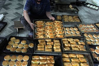A worker is sorting egg puffs and patties at a factory oven ahead of Eid Al-Fitr, which marks the end of the holy month of Ramadan, in Srinagar, Kashmir, on April 7, 2024. (Photo by Faisal Khan/NurPhoto via Getty Images)