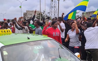 epaselect epa10828160 People wave Gabon national flags as they celebrate in the streets of Akanda, Gabon, 30 August 2023. Members of the Gabonese army on 30 August announced on national television that they were canceling the election results and putting an end to Gabonese President Ali Bongo's regime, who had been declared the winner.  EPA/STRINGER