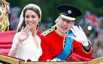 LONDON, UNITED KINGDOM - APRIL 29: (EMBARGOED FOR PUBLICATION IN UK NEWSPAPERS UNTIL 24 HOURS AFTER CREATE DATE AND TIME) Catherine, Duchess of Cambridge and Prince William, Duke of Cambridge (wearing his red tunic uniform of the Irish Guards, of which he is Colonel) travel down The Mall, on route to Buckingham Palace, in the 1902 State Landau horse drawn carriage following their wedding ceremony at Westminster Abbey on April 29, 2011 in London, England. The marriage of Prince William, the second in line to the British throne to Catherine Middleton was led by the Archbishop of Canterbury and was attended by 1900 guests, including foreign Royal family members and heads of state. Thousands of well-wishers from around the world have also flocked to London to witness the spectacle and pageantry of the Royal Wedding. (Photo by Max Mumby/Indigo/Getty Images)