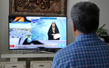 TEHRAN, IRAN - APRIL 19: A man watches tv reporter in Tehran, Iran after Iranian official TV confirms 'massive explosions' in central Isfahan province, as US officials confirm Israel carried out strike inside Iran, on April 19, 2024. (Photo by Fatemeh Bahrami/Anadolu via Getty Images)