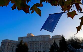 epa10332370 A NATO flag waves over the Parliament Palace building that will host NATO Foreign Ministers Meeting next week, in Bucharest, Romania, 27 November 2022. Foreign Ministers from NATO countries will gather in Romania's capital on 29-30 November 2022 to tackle Russia s invasion in Ukraine, NATO s support for Kyiv administration and regional partners and to find new ways to strengthen the Eastern flank of the alliance.  EPA/Robert Ghement