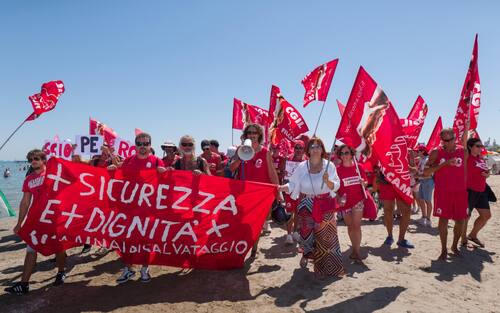 Sciopero simbolico dei bagnini oggi lungo il litorale della provincia di Rimini, dove i lavoratori del servizio di salvataggio hanno protestato per chiedere condizioni lavorative più eque. Al centro della mobilitazione, la richiesta di turni più sostenibili, nuove assunzioni e un servizio di salvataggio strutturato in maniera più sicura ed efficiente.

La protesta, indetta nel pieno della stagione estiva, non ha comportato interruzioni del servizio: grazie alla precettazione disposta dalla Prefettura, i bagnini hanno comunque garantito la sorveglianza in torretta, mentre la manifestazione si è svolta in forma ordinata.

Il corteo è partito intorno alle 12.30 dalla zona dei bagni 36-37 di Rimini, snodandosi lungo il litorale fino a raggiungere il piazzale Boscovich. Nessun disagio segnalato per i turisti presenti in spiaggia. Rimini, 9 agosto 2025. ANSA/Ph Dorin Mihai, Pasquale Bove

____

EN:

Italy: Rimini lifeguards hold symbolic strike, no impact on beach safety. Prefect orders mandatory service

RIMINI, Italy, Aug 9 (ANSA) – Lifeguards along Rimini’s coastline staged a symbolic strike on Saturday to protest working conditions during the peak summer season. The workers are demanding more manageable shift schedules, additional personnel, and improved safety protocols for rescue operations.

Despite the strike announcement, no disruption to beach safety was reported. Under an order issued by the Prefect, lifeguards were required to remain at their posts, ensuring continuous coverage of the shoreline.

The demonstration, which unfolded without incident, included a peaceful march beginning at 12:30 p.m. near Rimini bathing areas 36–37 and proceeding along the seafront to Piazzale Boscovich. Tourists and beachgoers were largely unaffected. Rimini (Italy) august 9 2025, ANSA/Ph Dorin Mihai, Pasquale Bove