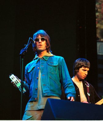 UNITED KINGDOM - JULY 21:  WEMBLEY STADIUM  Photo of OASIS, L-R: Liam Gallagher, Noel Gallager - performing live onstage  (Photo by Benedict Johnson/Redferns)
