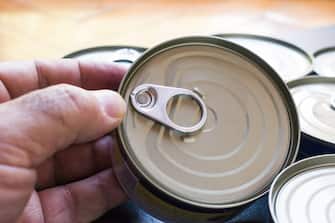Mature man holding canned food can. Long shelf life food .