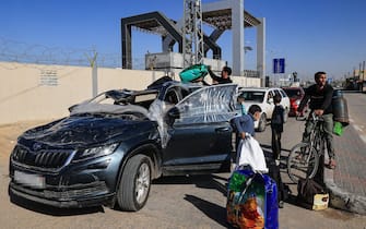 A man driving a damaged car picks-up relatives returning to the Gaza Strip via the Rafah crossing with Egypt, hours after the start of a four-day truce in battles between Israel and Palestinian Hamas militants, on November 24, 2023. A four-day truce in the Israel-Hamas war began on November 24, with hostages set to be released in exchange for prisoners in the first major reprieve in seven weeks of war that have claimed thousands of lives. (Photo by SAID KHATIB / AFP) (Photo by SAID KHATIB/AFP via Getty Images)