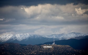 Los Angeles, CA - March 06: Two people take in the view of the famous Hollywood sign, with a backdrop of snow-capped San Gabriel Mountains, from atop 
Kenneth Hahn State Recreation Area, in the Baldwin Hills area of Los Angeles, CA, Monday, March 6, 2023. (Jay L. Clendenin / Los Angeles Times)