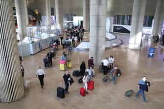 epa09608872 Passengers walk at the Ben Gurion International Airport near Tel Aviv, Israel, 28 November 2021. The Israeli government approved on 28 November a ban on arriving foreigners for 14 days over concerns of the new B.1.1.529 Coronavirus variant Omicron.  EPA/ABIR SULTAN