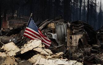 Una bandiera americana fra le macerie bruciate a Greenville