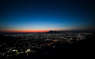 The sun sets over the Mount Vesuvius volcano (Rear) and the city of Naples, Campania, on April 24, 2020 during the country's lockdown aimed at curbing the spread of the COVID-19 infection, caused by the novel coronavirus. (Photo by ANDREAS SOLARO / AFP)