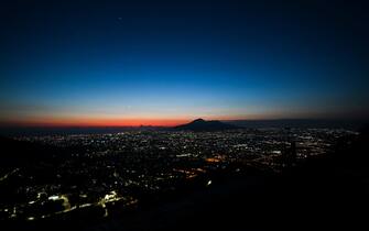 The sun sets over the Mount Vesuvius volcano (Rear) and the city of Naples, Campania, on April 24, 2020 during the country's lockdown aimed at curbing the spread of the COVID-19 infection, caused by the novel coronavirus. (Photo by ANDREAS SOLARO / AFP)