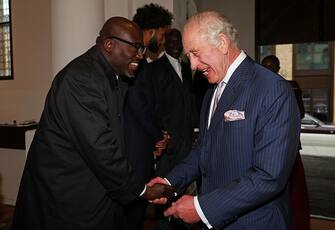 LONDON, ENGLAND - OCTOBER 18:  King Charles III shakes hands as he welcomes British editor-in-chief of British Vogue Edward Enninful during a reception for African business leaders, at the Garrison Chapel, Chapel Barracks, on October 18, 2023 in London, England. The King met with African business leaders to learn about opportunities for young people and entrepreneurship in Africa ahead of his visit to the continent. (Photo by Adrian Dennis - WPA Pool/Getty Images)