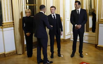 epa11185187 French President Emmanuel Macron (C), French First Lady Brigitte Macron (L) and Qatari Emir Sheikh Tamim bin Hamad Al Thani (R) greet Paris Saint Germain's soccer player Kylian Mbappe during the entrance ceremony at the Elysee Palace before an official dinner on the sidelines of the Qatari Emir's state visit in Paris, France, 27 February 2024.  EPA/YOAN VALAT / POOL  MAXPPP OUT