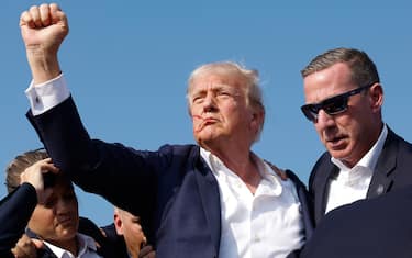 BUTLER, PENNSYLVANIA - JULY 13: Republican presidential candidate former President Donald Trump pumps his fist as he is rushed offstage during a rally on July 13, 2024 in Butler, Pennsylvania. Butler County district attorney Richard Goldinger said the shooter is dead after injuring former U.S. President Donald Trump, killing one audience member and injuring another in the shooting. (Photo by Anna Moneymaker/Getty Images)