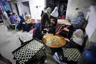 epa11256343 Egyptian women prepare 'kahk', Egyptian butter cookies, in Tanta, some 100km north of Cairo, Egypt, 02 April 2024. Egyptian Muslims prepare to celebrate Eid al-Fitr, the religious festival that marks the end of the fasting month of Ramadan. The Muslims' holy month of Ramadan is the ninth month in the Islamic calendar and it is believed that the revelation of the first verse in the Koran was during its last 10 nights. It is celebrated yearly by praying during the night time and abstaining from eating, drinking, and sexual acts during the period between sunrise and sunset. It is also a time for socializing, mainly in the evening after breaking the fast and a shift of all activities to late in the day in most countries  EPA/KHALED ELFIQI