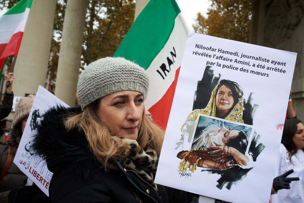 A  woman holds a cardboard reading 'Niloofar Hamedi, journalist who discovered the Amini story, has been arrested by the morality police'. Iranians of Toulouse organized a protest in Toulouse in solidarity with women and protesters in Iran, following the death of the young Iranian woman, Mahsa Amini, who died after being arrested by the Islamic republic's 'morality police'. Several hundreds of people participated to the protest. Police have said Amini fell ill as she waited with other women held by the morality police, who enforce strict rules in the Islamic republic requiring women to cover their hair and wear loose-fitting clothes in public. Since the death of Mahsa Amini, many protest took place in Iran, the NGO Iran Human Rights says that many protesters have been killed. The death of Mahsa Amini sparked protests worldwide.  Toulouse. France. December 3rd 2022. (Photo by Alain Pitton/NurPhoto via Getty Images)