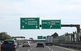 Highway with the signs of the locations of Southern Italy Naples Salerno Reggio Calabria Pescara and Bari with several cars running