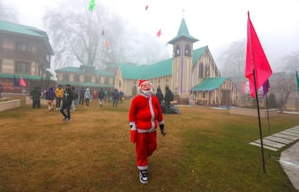 epa11043665 A boy dressed as a Santa Claus walks outside the Holy Family Catholic Church in Srinagar, the summer capital of Indian Kashmir, 25 December 2023. On this Christmas, Kashmir Christians prayed for peace in Mideast. Christmas Day is commonly observed by Christians around the world on 25 December to commemorate the birth of Jesus Christ.  EPA/FAROOQ KHAN