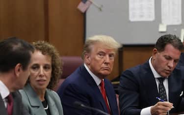 Former US President Donald Trump, center, with his defense team during his arraignment at court in New York, US, on Tuesday, April 4, 2023. Trump entered a not-guilty plea to 34 counts of falsifying business records in the first degree in a proceeding that took a little less than an hour. Photographer: Andrew Kelly/Reuters/Bloomberg via Getty Images