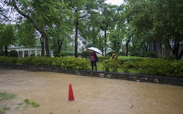 A resident stands on the side of a flooded road during heavy rain in Hong Kong, China, on Sept. 8, 2023. Hong Kong's heaviest rainstorm since records began in 1884 flooded the financial hub's streets and sent torrents of water rushing through subway stations, bringing much of the city to a standstill and forcing the stock market to scrap trading on Friday. Photographer: Justin Chin/Bloomberg via Getty Images