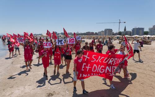 Sciopero simbolico dei bagnini oggi lungo il litorale della provincia di Rimini, dove i lavoratori del servizio di salvataggio hanno protestato per chiedere condizioni lavorative più eque. Al centro della mobilitazione, la richiesta di turni più sostenibili, nuove assunzioni e un servizio di salvataggio strutturato in maniera più sicura ed efficiente.

La protesta, indetta nel pieno della stagione estiva, non ha comportato interruzioni del servizio: grazie alla precettazione disposta dalla Prefettura, i bagnini hanno comunque garantito la sorveglianza in torretta, mentre la manifestazione si è svolta in forma ordinata.

Il corteo è partito intorno alle 12.30 dalla zona dei bagni 36-37 di Rimini, snodandosi lungo il litorale fino a raggiungere il piazzale Boscovich. Nessun disagio segnalato per i turisti presenti in spiaggia. Rimini, 9 agosto 2025. ANSA/Ph Dorin Mihai, Pasquale Bove

____

EN:

Italy: Rimini lifeguards hold symbolic strike, no impact on beach safety. Prefect orders mandatory service

RIMINI, Italy, Aug 9 (ANSA) – Lifeguards along Rimini’s coastline staged a symbolic strike on Saturday to protest working conditions during the peak summer season. The workers are demanding more manageable shift schedules, additional personnel, and improved safety protocols for rescue operations.

Despite the strike announcement, no disruption to beach safety was reported. Under an order issued by the Prefect, lifeguards were required to remain at their posts, ensuring continuous coverage of the shoreline.

The demonstration, which unfolded without incident, included a peaceful march beginning at 12:30 p.m. near Rimini bathing areas 36–37 and proceeding along the seafront to Piazzale Boscovich. Tourists and beachgoers were largely unaffected. Rimini (Italy) august 9 2025, ANSA/Ph Dorin Mihai, Pasquale Bove