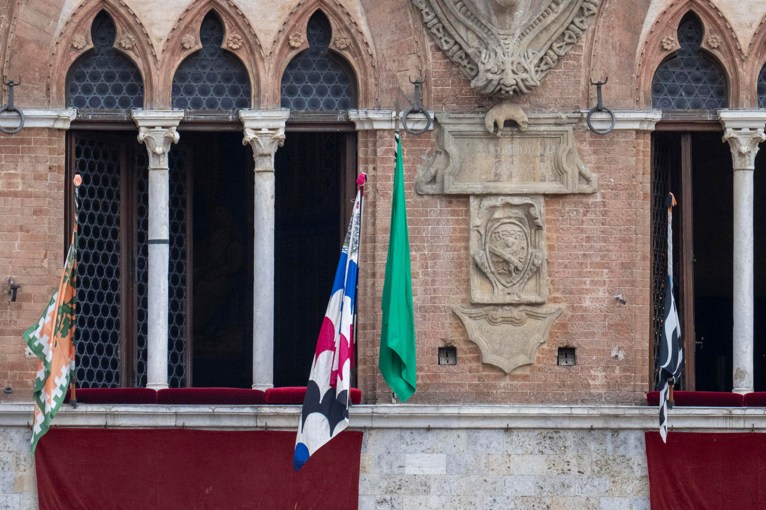 La bandiera verde esposta sulle trifore del Comune di Siena
