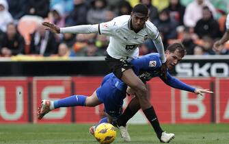 epa11209065 Cristhian Mosquera (L) of Valencia fights for the ball with Juanmi Latasa (R) of Getafe during the Spanish LaLiga soccer match between Valencia and Getafe in Valencia, Spain, 09 March 2024.  EPA/Biel Alino