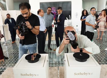 epa10645569 Videographers record 'The Eternal Pink' (R) and 'Estrela de FURA' gems during an unveiling event in Dubai, United Arab Emirates, 22 May 2023. Sotheby's Dubai unveiled on public display 'The Eternal Pink', a pink diamond weighing 10.57 carats and the ruby 'Estrela de FURA' at 55.22 carats, ahead of the 'Magnificent Jewels' sale in New York on 8 June 2023, with an estimated price of 35 and 30 million dollars respectively.  EPA/ALI HAIDER