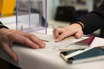 Employee checking documents, issuing boarding pass