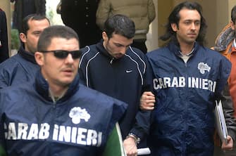 Naples, ITALY: Vincenzo Di Lauro, the boss of one of the Naples area's main mafia clans, is escorted out of the Italian Carabinieri headquarters, in Naples 27 March 2007. Di Lauro, 31, was arrested for "association with the mafia" in an apartment in Casalnuovo, northeast of the southern Italian city. He became head of the Di Lauro clan of the Camorran mafia after his father Paolo was arrested in September 2005. AFP PHOTO Francesco Pischetola (Photo credit should read FRANCESCO PISCHETOLA/AFP via Getty Images)