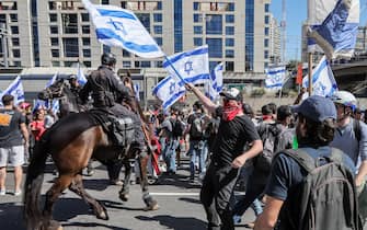Demonstrators confront Israeli mounted policemen during a rally against the government's controversial judicial overhaul bill in Tel Aviv on March 16, 2023. (Photo by JACK GUEZ / AFP) (Photo by JACK GUEZ/AFP via Getty Images)