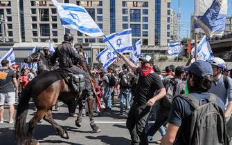 Demonstrators confront Israeli mounted policemen during a rally against the government's controversial judicial overhaul bill in Tel Aviv on March 16, 2023. (Photo by JACK GUEZ / AFP) (Photo by JACK GUEZ/AFP via Getty Images)