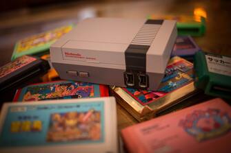 BANGKOK, THAILAND - 2018/07/13:  In this photo illustration, a Nintendo Classic Mini 'Nintendo Entertainment System' video game console first generation seen with a pile of Famicom games cartridges. (Photo Illustration by Guillaume Payen/SOPA Images/LightRocket via Getty Images)