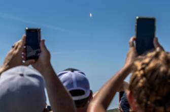epa10721172 People observe from the Playa Linda beach as the ESA Euclid Telescope mission lifts off on a SpaceX Falcon 9 rocket from Launch Complex 40 at the Kennedy Space Center, Florida, USA, 01 July 2023. According to NASA, the Euclid is a European Space Agency (ESA) mission, with contributions from NASA, designed to explore the composition and evolution of the dark universe. It will make a 3D map of the universe by observing billions of galaxies out to 10 billion light-years across more than a third of the sky. Euclid will be launched to an observing orbit at the Sun-Earth L2 Lagrange point.  EPA/CRISTOBAL HERRERA-ULASHKEVICH