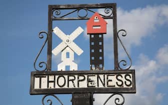 Thorpeness village sign showing the House in the Clouds and windmill, Suffolk, England. (Photo By: Geography Photos/Universal Images Group via Getty Images)