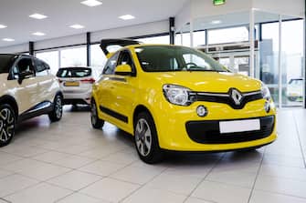 yellow renault twingo in a showroom for sale