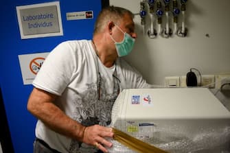 An employee of the National Forensic Institute INPS prepares a DNA tester from the police, to be lend to a medical biology laboratory to be used to detect the COVID-19, in Marseille on April 14, 2020,  on the 29th day of a strict lockdown in France to stop the spread of COVID-19 (novel coronavirus). (Photo by Christophe SIMON / AFP) (Photo by CHRISTOPHE SIMON/AFP via Getty Images)