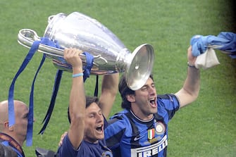 Inter Milan's Argentinian defender and captain Javier Aldemar Zanetti (L) and Inter Milan's Argentinian forward Alberto Milito (R) show the Champions League Trophy to their supporters at San Siro stadium in Milan after their team's victory against Bayern Munich in the UEFA Champions league final football match on May 23, 2010.  Inter beat Bayern Munich 2-0 to add the European title to their Serie A and domestic cup triumphs allowing Inter Milan's Portuguese coach Jose Mourinho to become just the third coach to win the continental crown with two different teams.    AFP PHOTO DAMIEN MEYER (Photo credit should read DAMIEN MEYER/AFP via Getty Images)