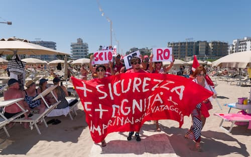 Sciopero simbolico dei bagnini oggi lungo il litorale della provincia di Rimini, dove i lavoratori del servizio di salvataggio hanno protestato per chiedere condizioni lavorative più eque. Al centro della mobilitazione, la richiesta di turni più sostenibili, nuove assunzioni e un servizio di salvataggio strutturato in maniera più sicura ed efficiente.

La protesta, indetta nel pieno della stagione estiva, non ha comportato interruzioni del servizio: grazie alla precettazione disposta dalla Prefettura, i bagnini hanno comunque garantito la sorveglianza in torretta, mentre la manifestazione si è svolta in forma ordinata.

Il corteo è partito intorno alle 12.30 dalla zona dei bagni 36-37 di Rimini, snodandosi lungo il litorale fino a raggiungere il piazzale Boscovich. Nessun disagio segnalato per i turisti presenti in spiaggia. Rimini, 9 agosto 2025. ANSA/Ph Dorin Mihai, Pasquale Bove

____

EN:

Italy: Rimini lifeguards hold symbolic strike, no impact on beach safety. Prefect orders mandatory service

RIMINI, Italy, Aug 9 (ANSA) – Lifeguards along Rimini’s coastline staged a symbolic strike on Saturday to protest working conditions during the peak summer season. The workers are demanding more manageable shift schedules, additional personnel, and improved safety protocols for rescue operations.

Despite the strike announcement, no disruption to beach safety was reported. Under an order issued by the Prefect, lifeguards were required to remain at their posts, ensuring continuous coverage of the shoreline.

The demonstration, which unfolded without incident, included a peaceful march beginning at 12:30 p.m. near Rimini bathing areas 36–37 and proceeding along the seafront to Piazzale Boscovich. Tourists and beachgoers were largely unaffected. Rimini (Italy) august 9 2025, ANSA/Ph Dorin Mihai, Pasquale Bove