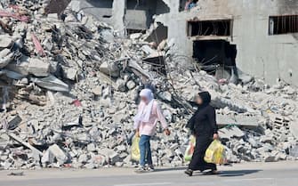 Due donne camminano a Gaza dopo i bombardamenti israeliani