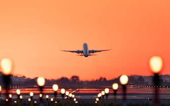 Airplane taking off at sunrise,