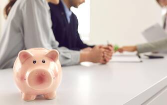 Banner with piggy bank and young couple consulting financial advisor or bank manager